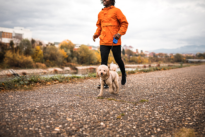 Man and dog running together near the river